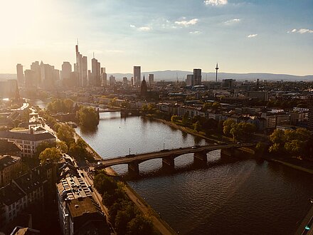 Frankfurter Skyline in der Abendsonne aus Richtung Offenbach fotografiert mit dem Main und Brücken im Vordergrund