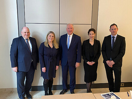 Zu sehen ist ein Gruppenbild mit insgesamt fünf Personen vor einer Wand. Es handelt sich hierbei um Ansgar Roese, Geschäftsführer Wirtschaftsförderung Frankfurt; Wirtschaftsdezernentin Stephanie Wüst; IHK-Präsident Ulrich Caspar; Patricia Borna, Geschäftsführerin Unternehmenskommunikation der IHK Frankfurt; Dr. Alexander Theiss, Geschäftsführer Geschäftsfeld Standortpolitik der IHK Frankfurt. 